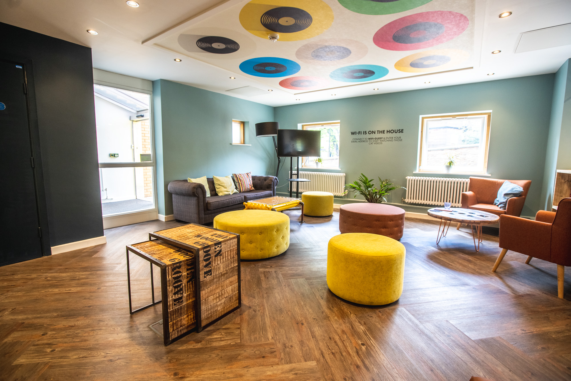 Seating area in Jonas Hotel reception with vinyl ceiling artwork.