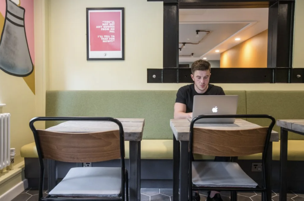 Man working on laptop at a desk at Jons Hotel
