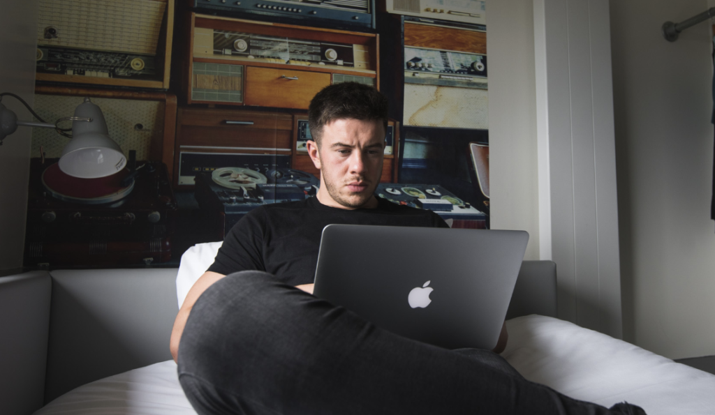 Guest working on his laptop in his hotel room at Jonas long-stay hotel in Sheffield